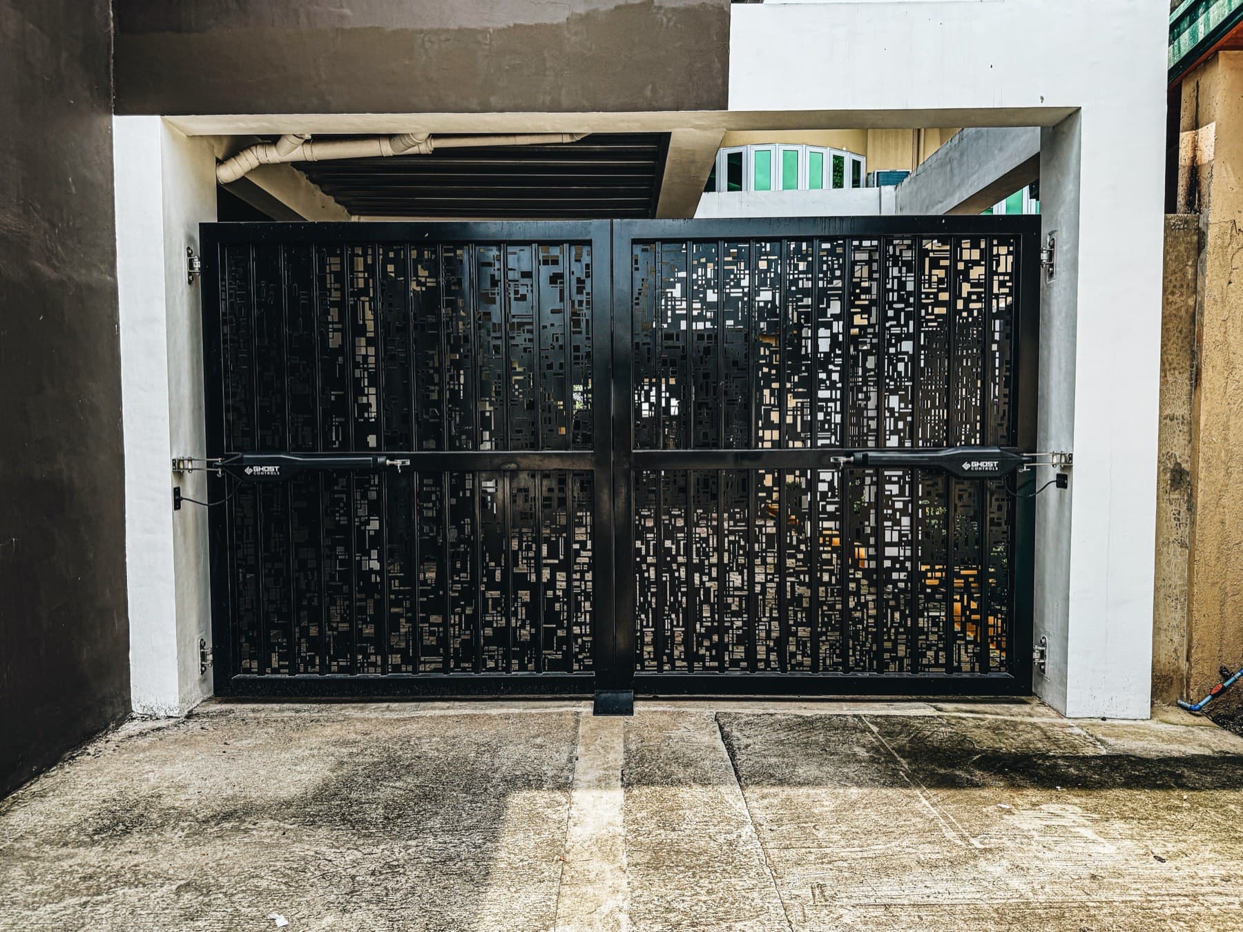 Installed black architectural gate with detailed patterned infill