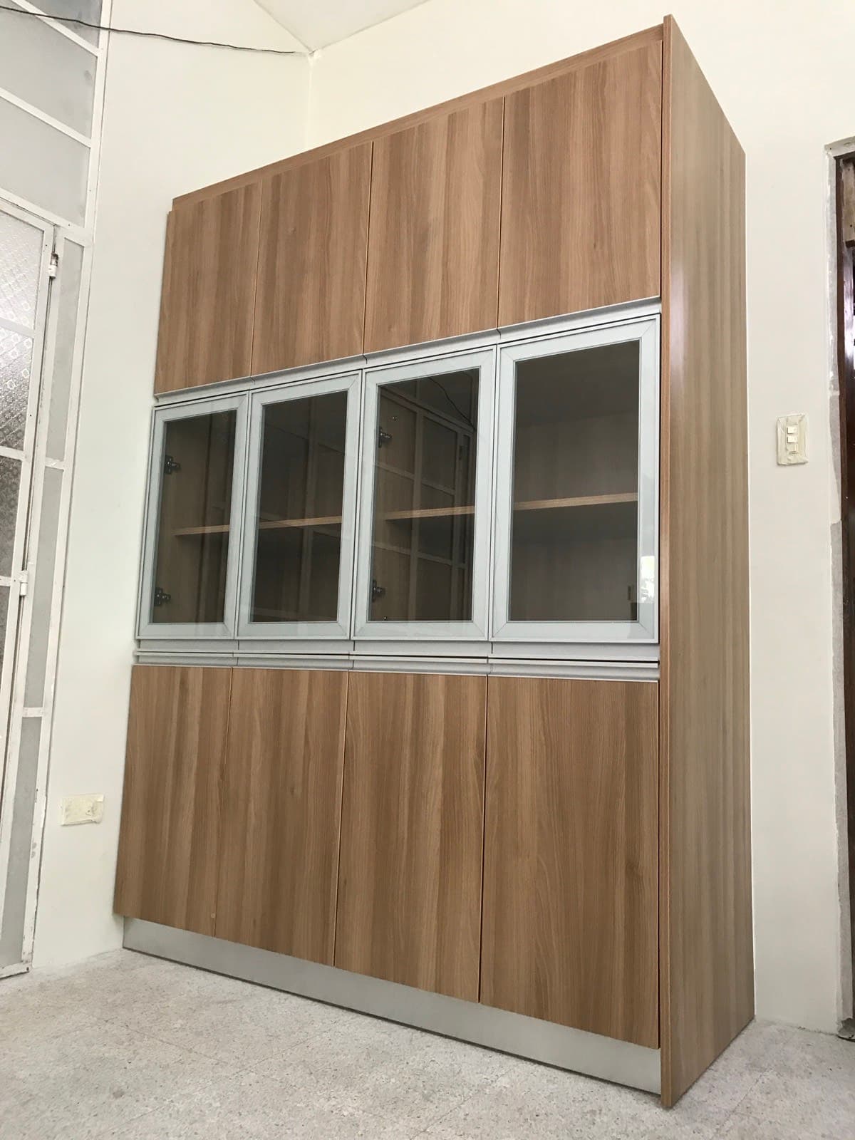 Tall built-in cabinet with framed glass doors