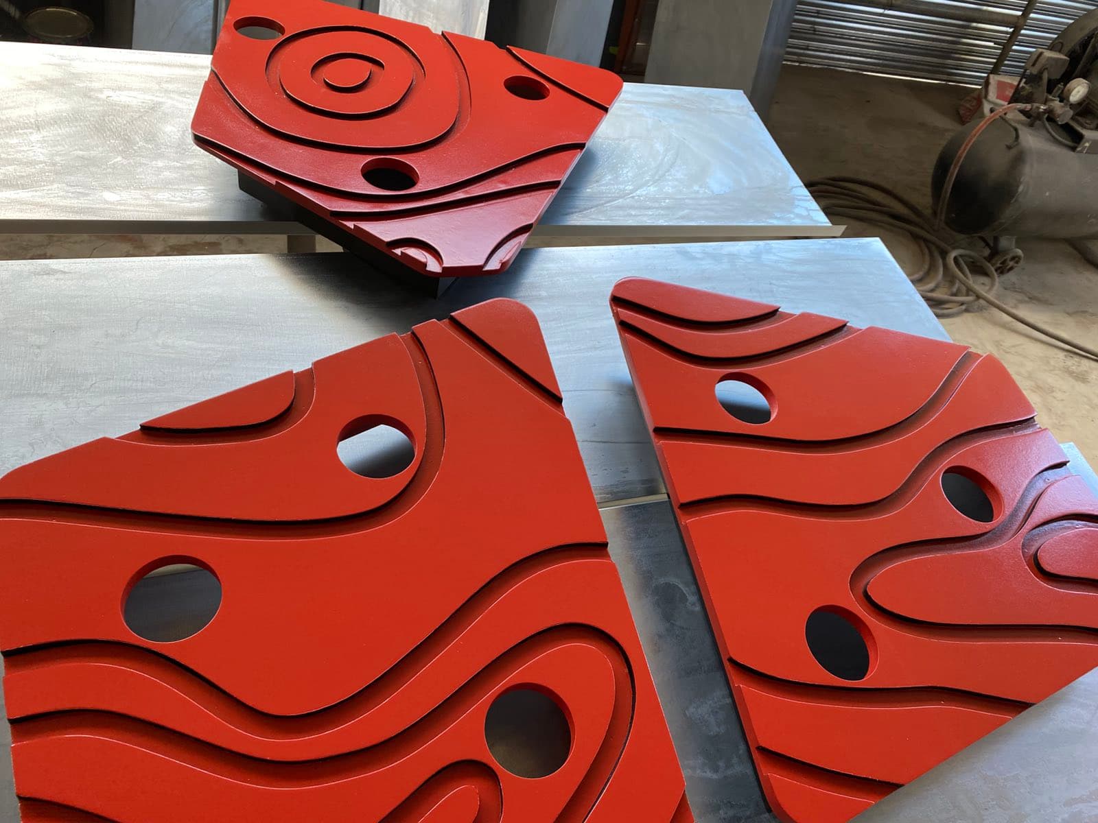 Laser-cut decorative steel panels in red finish inside the workshop